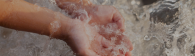 Child's hand scooping splashing water