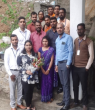 A group of people, one with a bouquet of flowers.