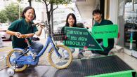 people holding up signs and a small bike