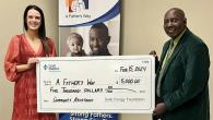 Two people holding a large check made out to "A Fathers Way"