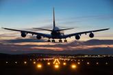A jet landing on a lighted runway at dusk