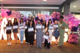 A group holding awards in front of balloons