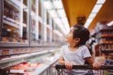 A child seated in a shopping at looking at items