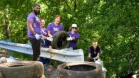Volunteers pulling used tires out of the forested area.
