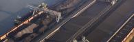 aerial view of huge transport barges being filled with possibly coal. 