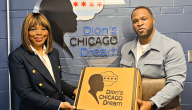 Two people holding a box "Dion's Chicago Dream" on the front and on the wall behind them.