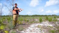 Forester gesturing at dry ground while speaking
