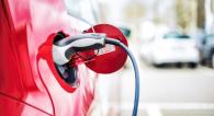 A red electric vehicle plugged in.