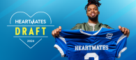 Damar Hamlin holding a blue "Heartmates" football jersey.