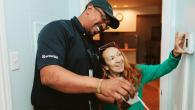 An Entergy employee helping a customer adjust a thermostat