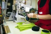 Worker in a factory sewing on a zipper