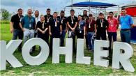 Kohler employees outside behind a large Kohler sign