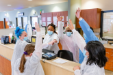 nurses raising their hands at a nursing station