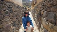 An adult and child standing together on a narrow cobblestone street