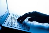 A hand typing on a laptop keyboard.