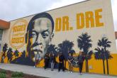 AEG team members pose outside Compton High School in front of the Andre “Dr. Dre” Young Performing Arts Center mural during a campus visit focused on career exposure and community engagement.