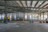A large open building with concrete floor being poured and set.
