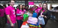Volunteers packing colorful bags in two lines.