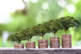 Digital imagery of small trees growing out of stacks of coins.
