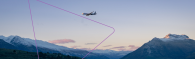 A plane in flight over mountain terrain.