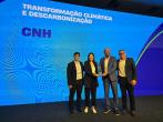 four people holding an award on a stage