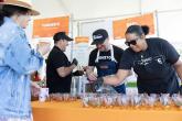 Volunteers pouring drinks on a table with an orange covering