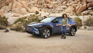 Person standing next to a Subaru vehicle