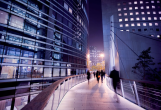 People on a walkway between two tall buildings