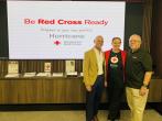 Three people standing in front of a board that reads "Be Red Cross Ready"