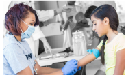 A medical provider cleans the arm of a child in a clinic setting