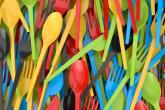 Close up of a pile of colorful plastic cutlery