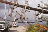 Downed power poles, with Entergy vehicles at work