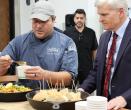 Someone dishing out food as the Senator looks on