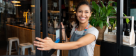 person smiling and opening a door