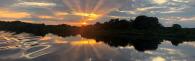 Sun rising over a river 