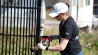 Entergy volunteer painting a gate