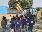A group of students around farm machinery