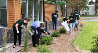 A team of volunteers picking up trash outside a building.