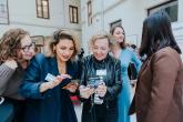 Women dressed in business attire eagerly looking at phones