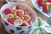 A healthy breakfast shown with oats, strawberries and bananas.