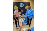 Former professional baseball and football player Brian Jordan (l) and Aflac Incorporated and Aflac U.S. President Virgil Miller (r) hand a My Special Aflac Duck to Leighton, a six year old patient at SSM Health Cardinal Glennon Children's Hospital in St. Louis.