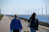 people walking by windmills