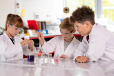 Young students in white coats doing lab experiments