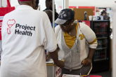 Person wearing Project Health shirt helps someone to sign up
