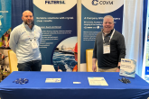 Mike Mongell and Joel Eaton standing behind a Covia desk at an event