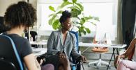 Office meeting with three women seated in an open environment