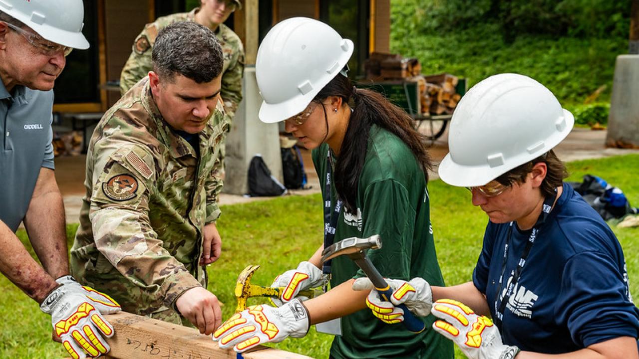 Instructor showing students how to build a structure 