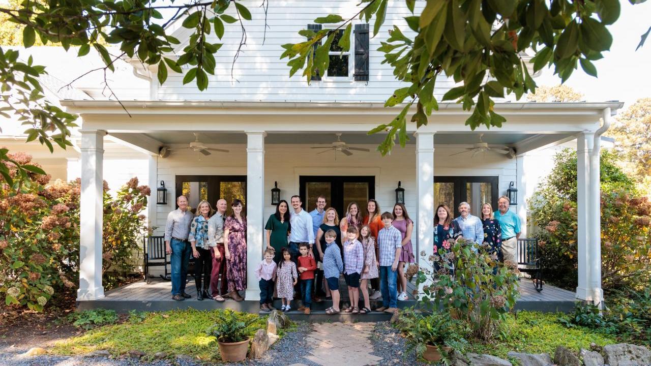 family stands in front of house