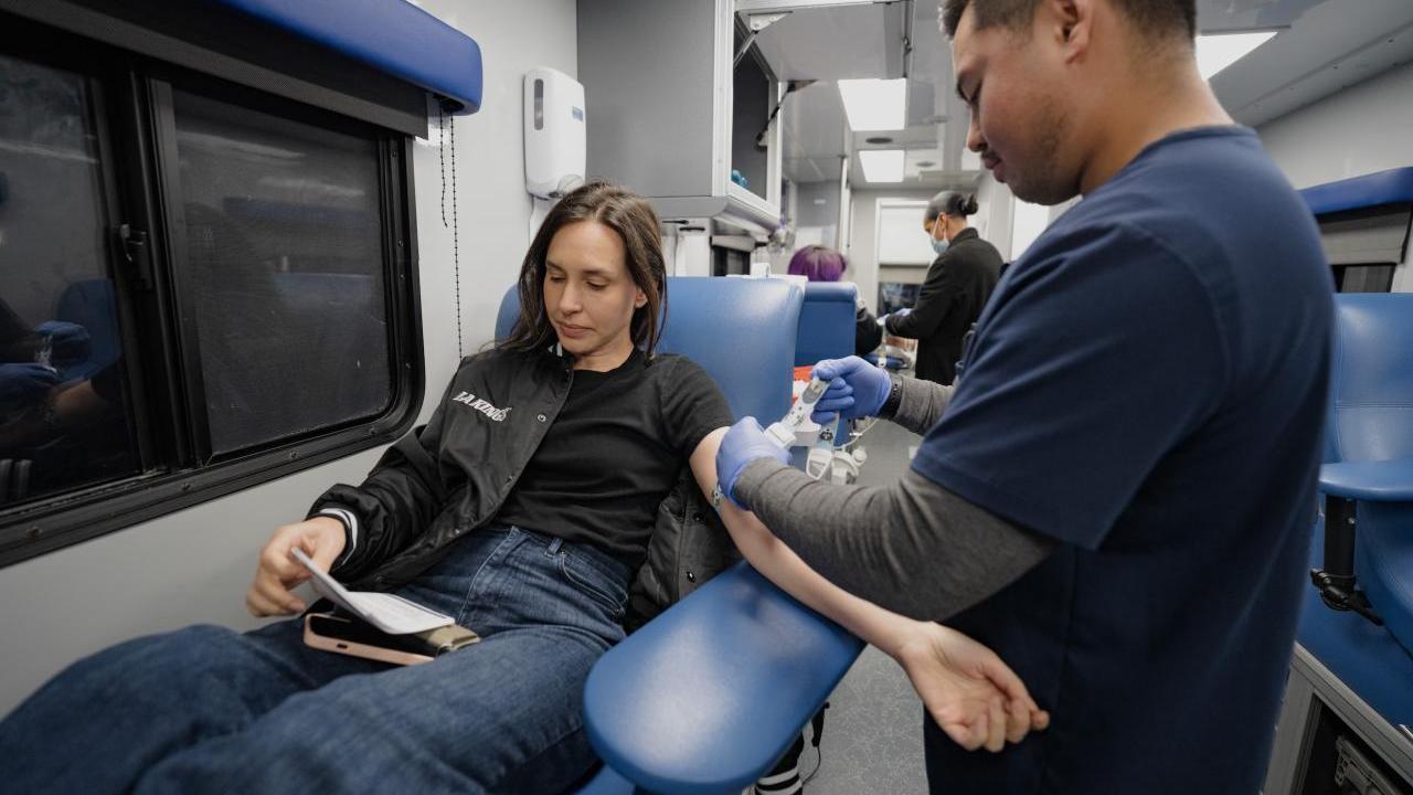 A woman donates blood during the LA Kings blood drive at Crypto.com Arena in Los Angeles, CA.