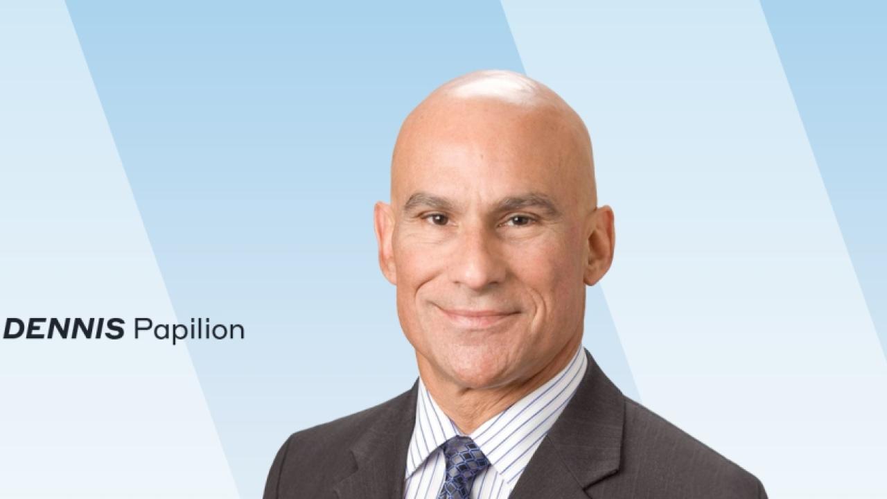 headshot of Dennis Papilion on a blue background with his name to the left